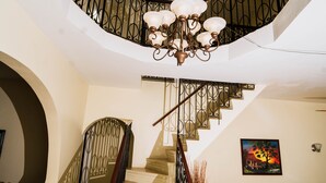 Un intérieur à plusieurs niveaux comprenant un escalier, un coin repas et des œuvres d’art.