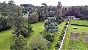 Ein gepflegter Garten mit verschiedenen Bäumen und einem ordentlich gestutzten Rasen.