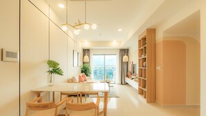 A modern living room with a dining area, a large window, and a balcony. - EEM Apartments Central (Ho Chi Minh City)