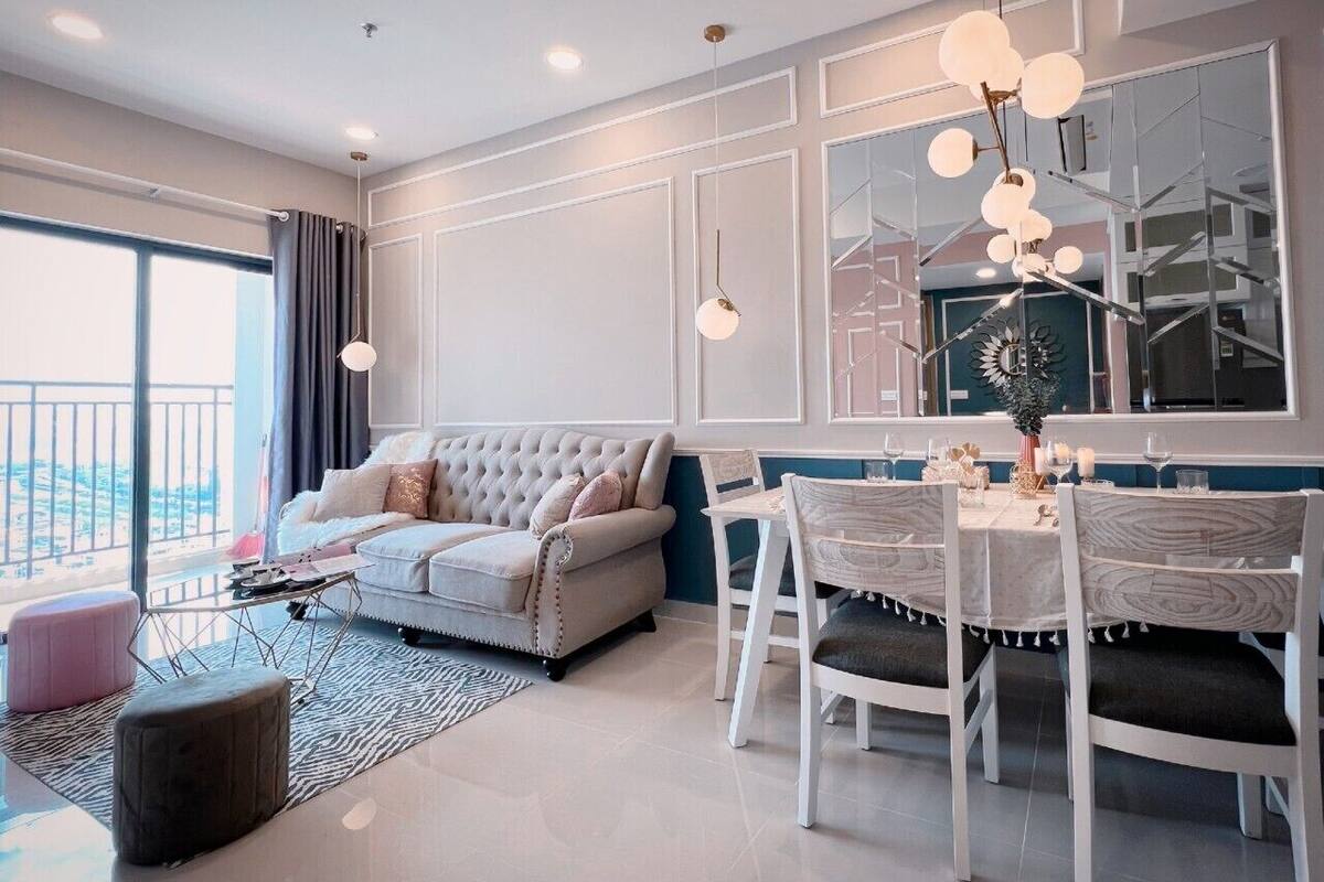 Een moderne woonkamer met een bank, poef, eettafel en stoelen.