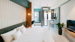 A modern hotel room with a large bed, a TV, a seating area with a view, and a potted plant. - EEM Apartments Central (Ho Chi Minh City)