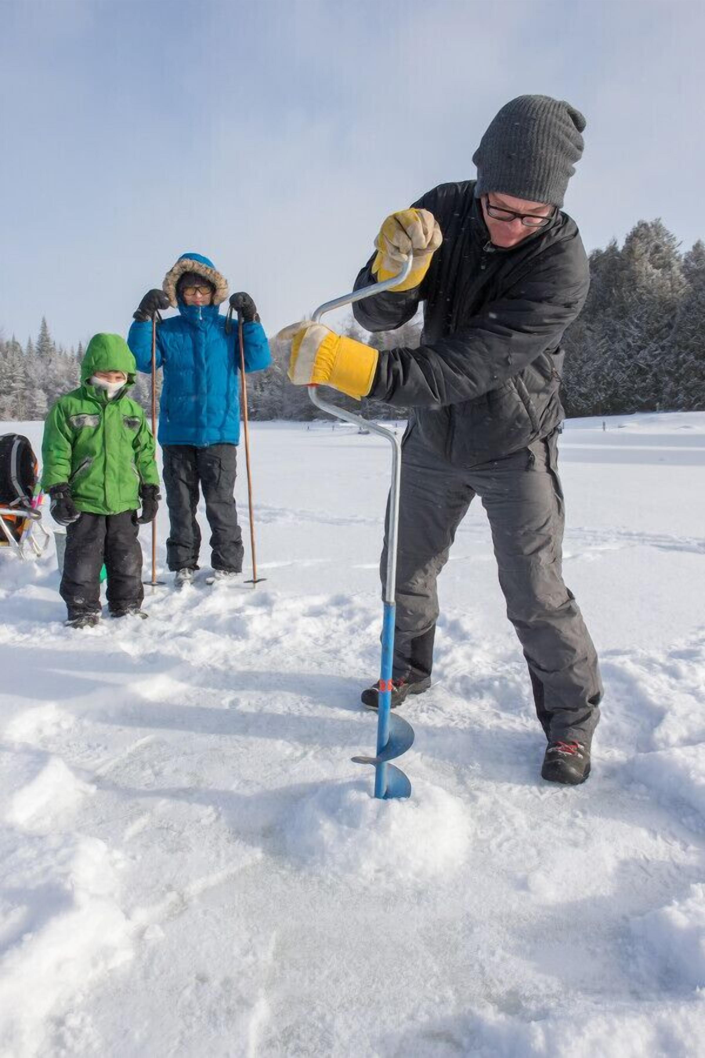 Una persona usando una herramienta metálica en la nieve.