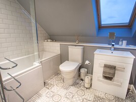 Un baño con bañera, inodoro y lavamanos.