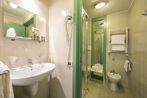 Un bagno con lavandino, specchio, asciugacapelli e portasciugamani.