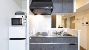 Una cucina compatta con forno a microonde, forno e lavello.