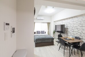 Ein modernes Hotelzimmer mit Bett, Schreibtisch und Fernseher.