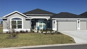 A single-story house with a front porch, a garage, and a well-maintained lawn.