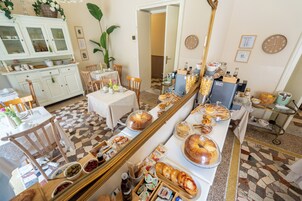 Un bufé de desayuno con diversas opciones de comida y un espejo grande que refleja la sala.
