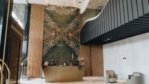 Et moderne receptionområde med en marmorvæg, et receptionistskab og siddepladser.