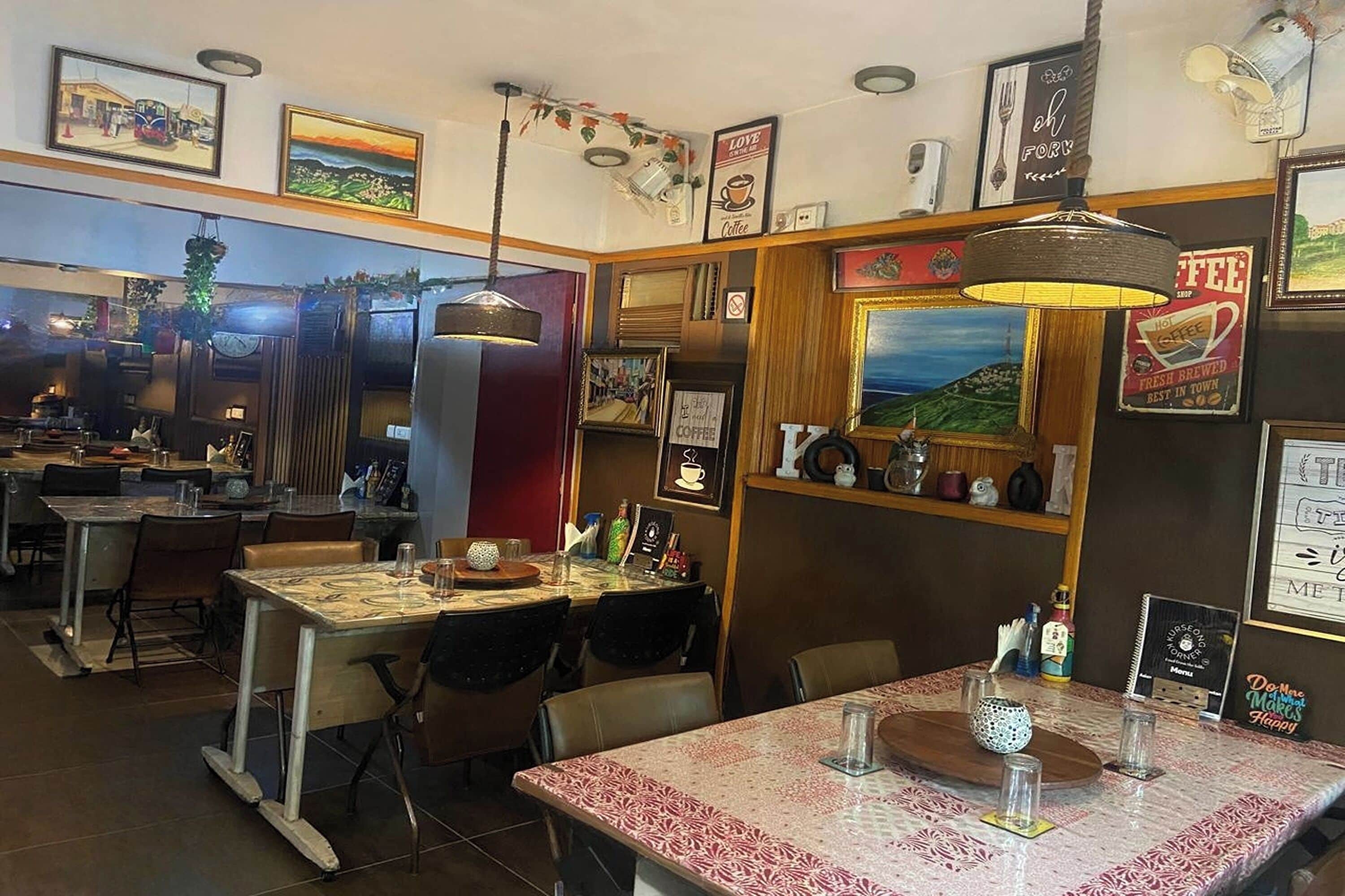 Um café acolhedor com decoração em madeira, quadros e tema de café.