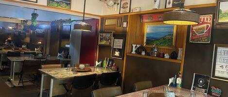 Um café acolhedor com decoração em madeira, quadros e tema de café.