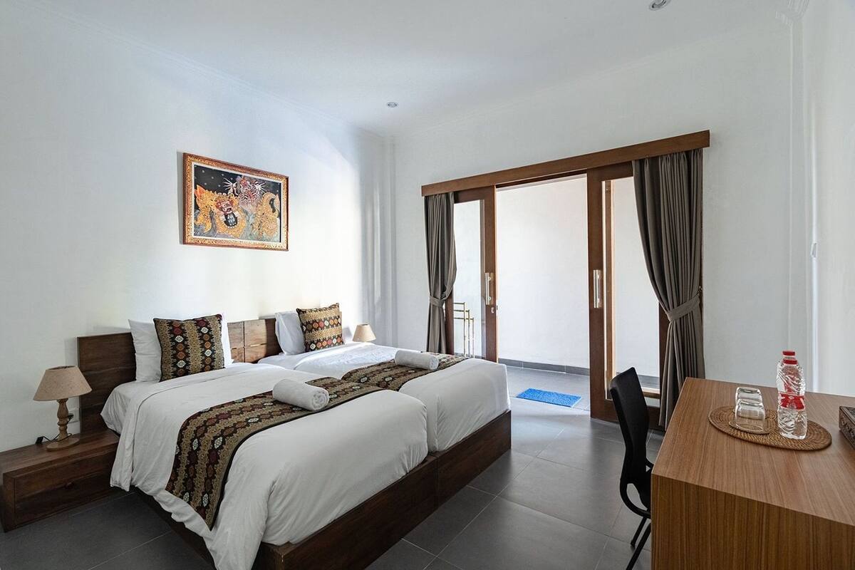 A hotel room with a large bed, a desk, and a view of the outdoors.