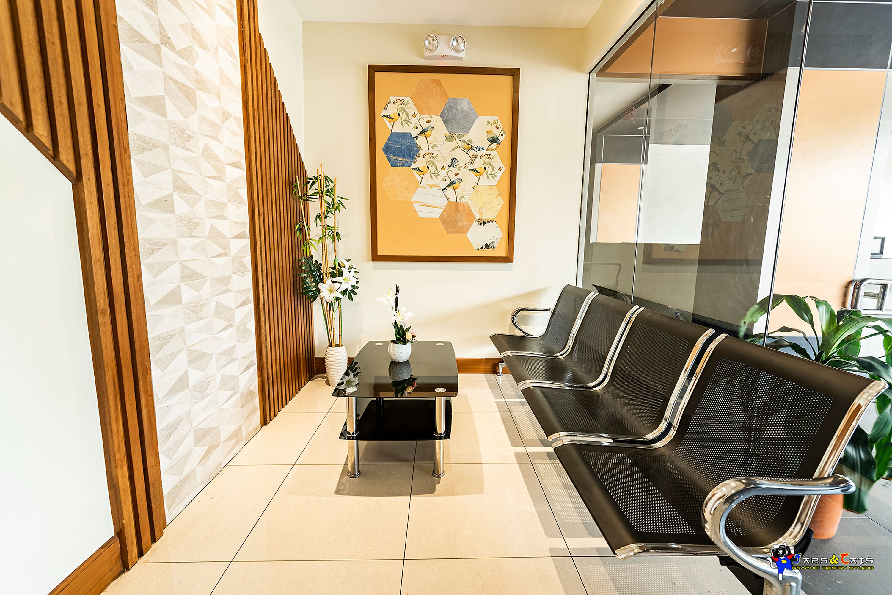 A reception area with a black leather sofa, a glass coffee table, and a geometric patterned wall.