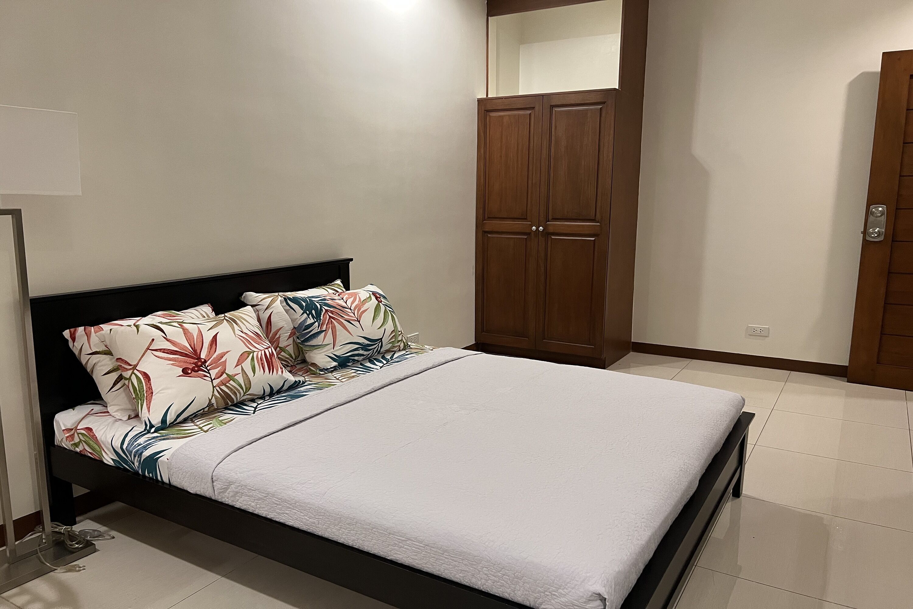 Ein Schlafzimmer mit Bett, Kleiderschrank und Nachttisch.