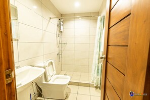 Un baño con inodoro, lavabo y ducha.