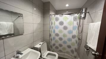 A modern bathroom with a toilet, sink, and shower curtain.