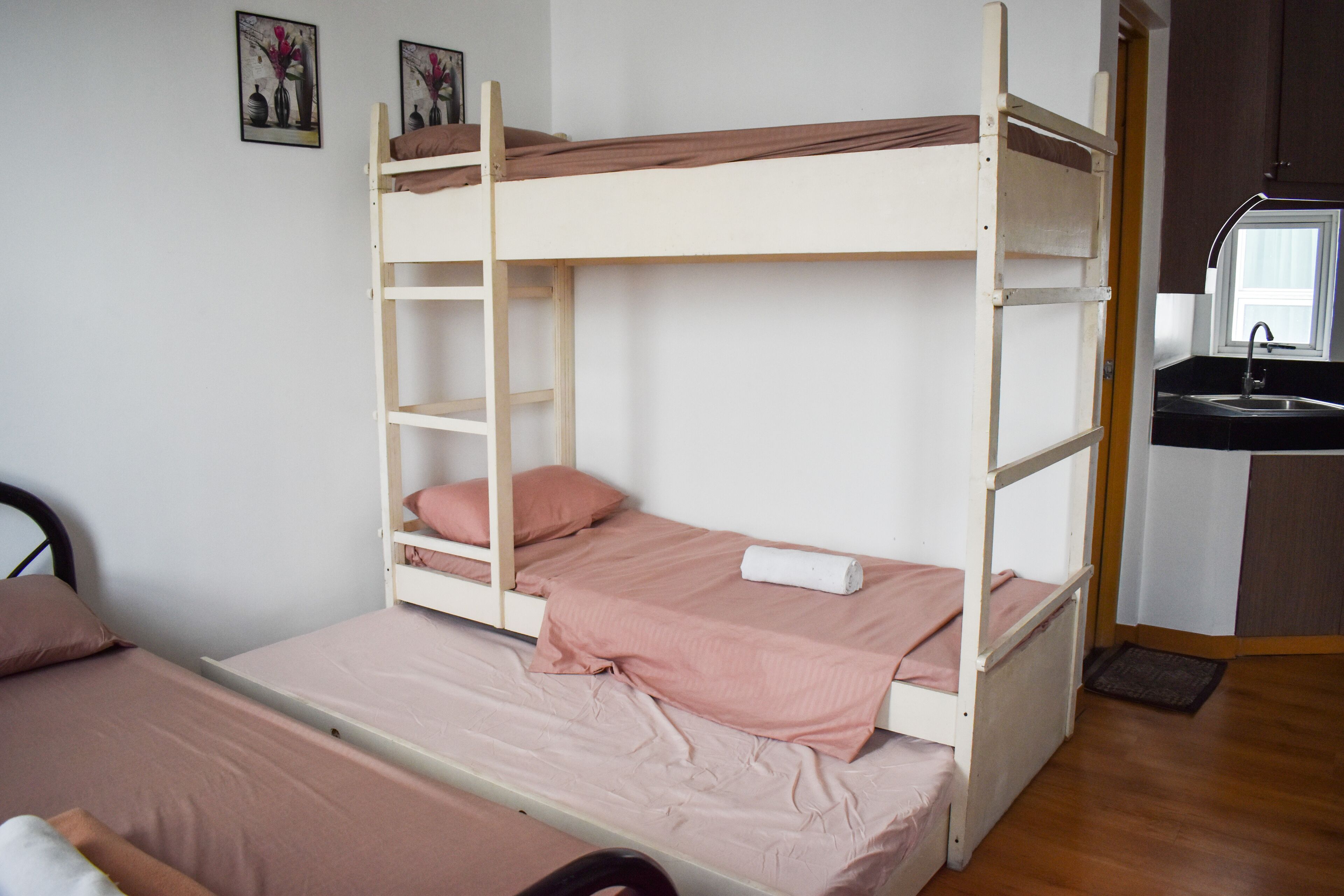 A bunk bed with a ladder, a sink, and a small kitchen area.