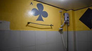 A bathroom with yellow walls, a hand dryer, and a towel rack.