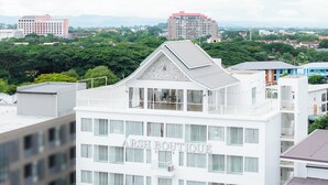 Un immeuble à plusieurs étages, doté de balcons et d’une enseigne indiquant « ARSH BOUTIQUE ».