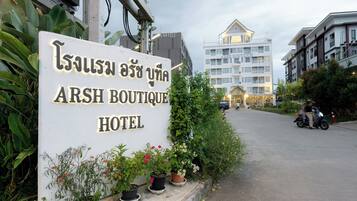 Señal del Hotel ARSH Boutique, con plantas en macetas al frente.