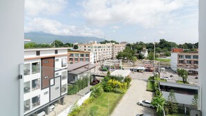 Un quartier résidentiel avec des immeubles modernes, un parking et une vue sur les montagnes lointaines.