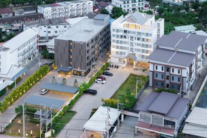 Vista aérea de una zona comercial con varios edificios, incluyendo un hotel de varios pisos y balcones.