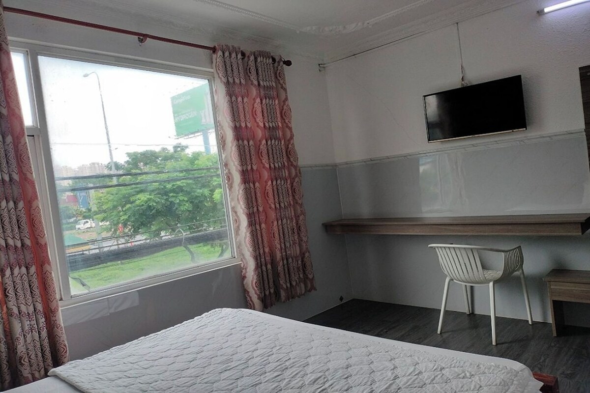 Une chambre d’hôtel équipée d’un lit, d’un téléviseur fixé au mur, d’un bureau et d’une chaise.