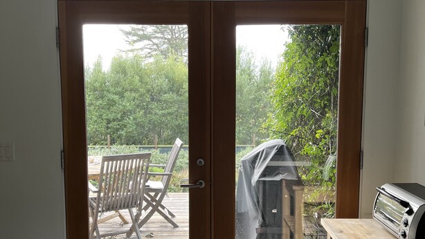 A kitchen with a sliding glass door leading to an outdoor deck. - Garden apt. above the beach close to hiking trails and beach. (Stinson Beach)