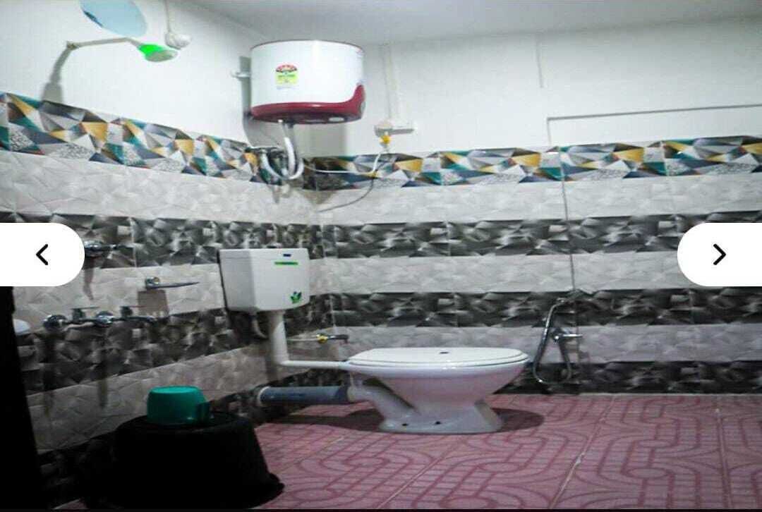 Une salle de bain équipée de toilettes, d’un sèche-mains et d’un chauffe-eau.