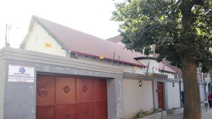 A building with a red garage door and a sign for armed response services. - Defountain Guest house (Johannesburg)
