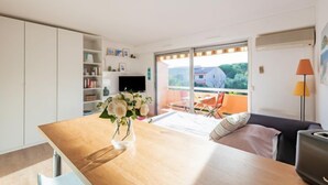 Een moderne keuken met een houten tafel, een bloevas en een televisie op de achtergrond.