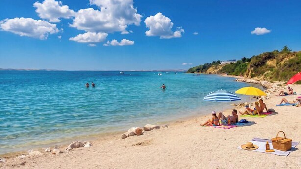 En strand med kristallklart blått vatten, folk som badar och strandbesökare som kopplar av under parasoller.