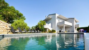 Ett modernt hotell med en swimmingpool, solstolar och en lekplats för barn.