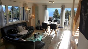 Ein modernes Wohnzimmer mit Sofa, Couchtisch und Essbereich.