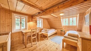 Una cabaña acogedora de madera con una cama en altillo, un escritorio y una silla.