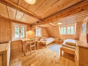 A cozy wooden cabin with a loft bed, a desk, and a chair.
