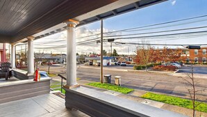 A covered outdoor area with a view of a street, buildings, and parked cars. - AC*Boutique Apt. Albany dwntn*KING*Queen*Full* 1 bath. PNW (Albany)