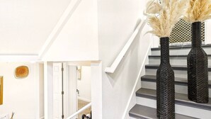 A staircase with black woven vases and pampas grass. - AC*Boutique Apt. Albany dwntn*KING*Queen*Full* 1 bath. PNW (Albany)