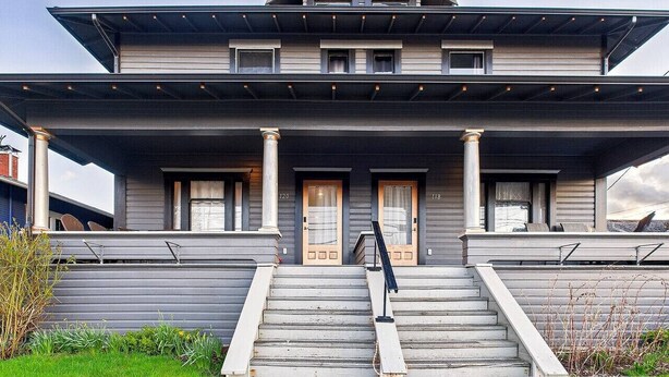 A two-story house with a covered front porch, a set of stairs leading to the entrance, and a small garden area. - AC*Boutique Apt. Albany dwntn*KING*Queen*Full* 1 bath. PNW (Albany)