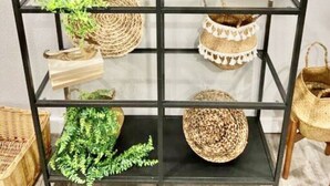 A black metal shelving unit with various decorative items, including woven baskets, a small potted plant, and a metal bowl. - Stay right downtown at a historical updated property (Albany)