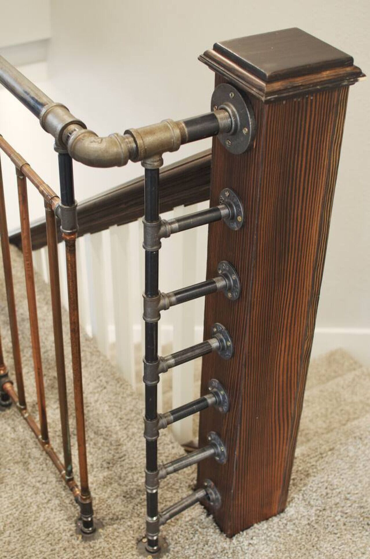 A wooden staircase railing with a metal handrail and a dark wooden base.