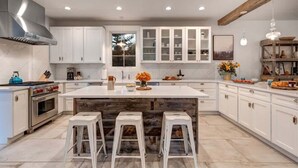 A modern kitchen with white cabinets, a large island, and a built-in oven. - Abode at Palomino Ridge, amazing views, nature (Jackson)