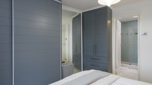 A bedroom with a bed, a wardrobe, and a bathroom with a shower. - San Lameer Villa Rentals 2818 (Southbroom)