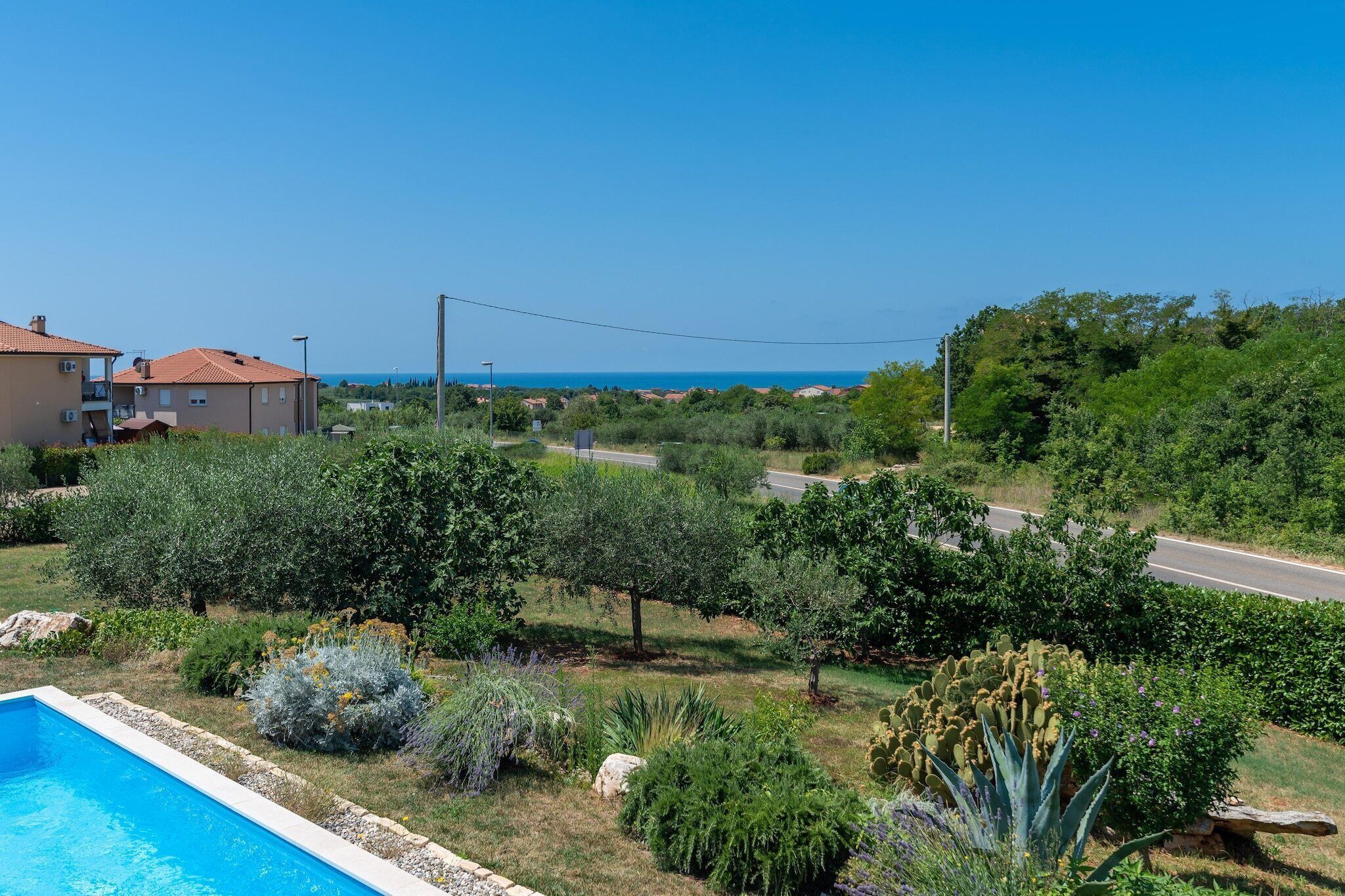 Un quartier résidentiel doté d’une piscine, d’une route et offrant une vue sur la mer.