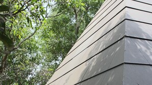 A modern building with a sloped roof and a concrete base. - Outpost (Alibag)