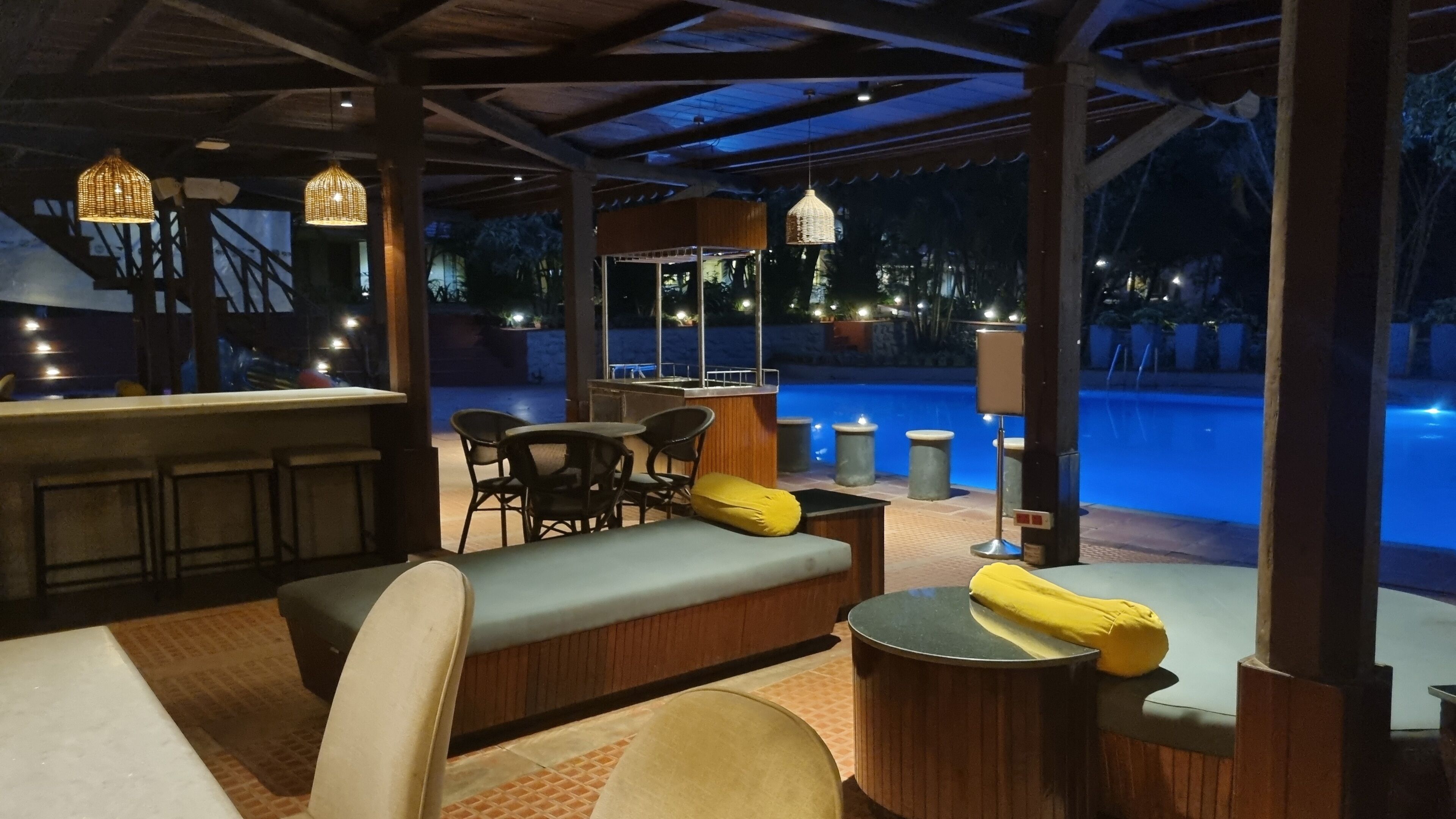 An outdoor seating area with a pool view, bar, and lounge chairs.