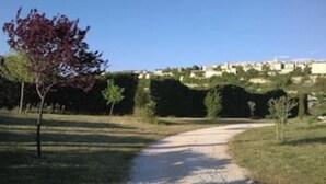A gravel path leading to a residential area with houses in the background. - Views of Sault, cycling, hiking, Mont Ventoux (Sault)