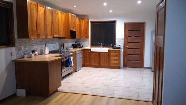 Una cocina moderna con armarios de madera, horno empotrado y lavavajillas.