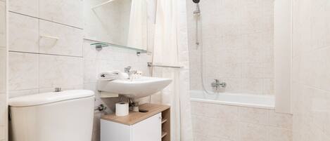 Un baño moderno con inodoro, lavamanos y ducha.