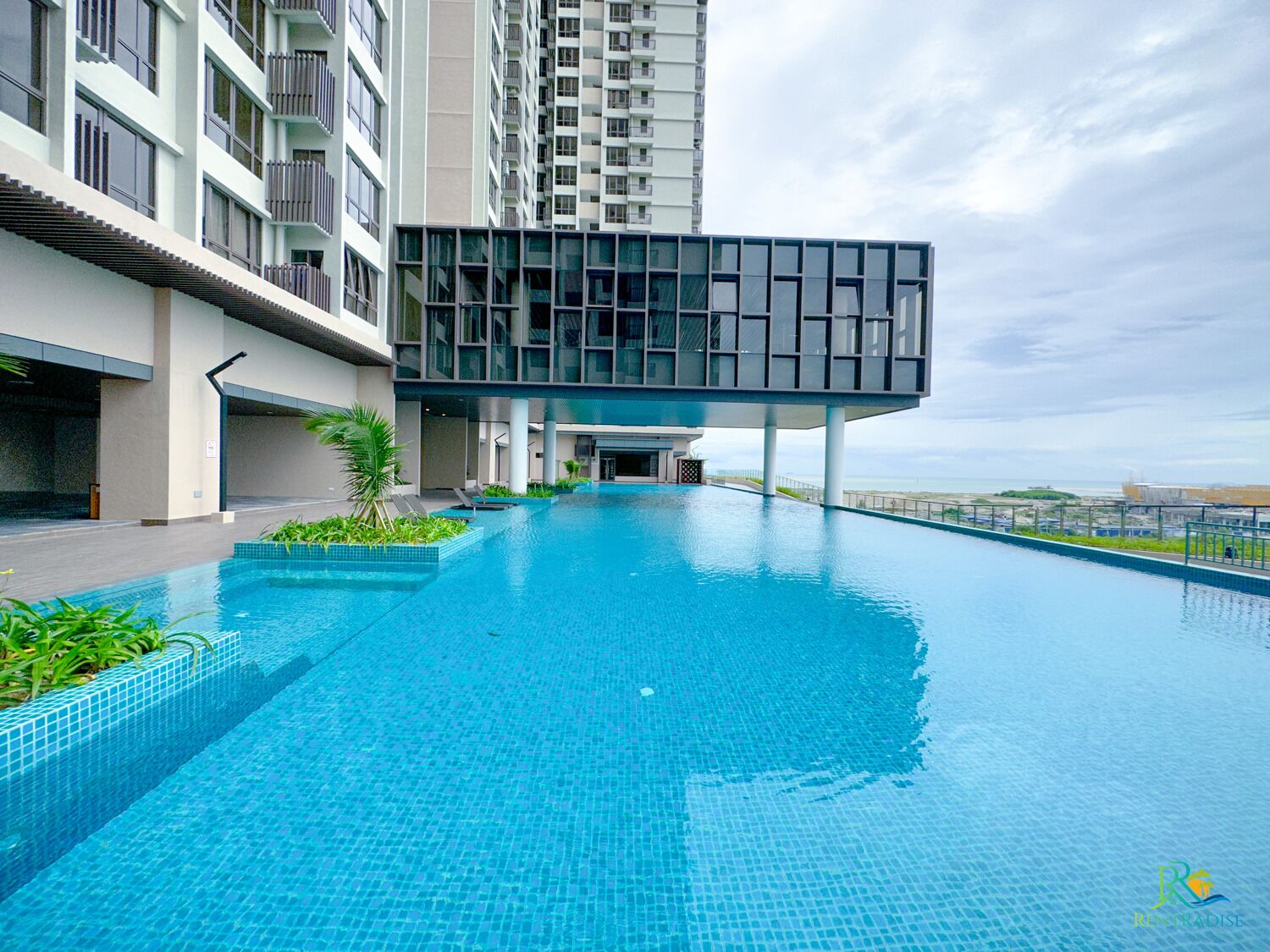 A modern swimming pool with a clear view of the ocean in the background.